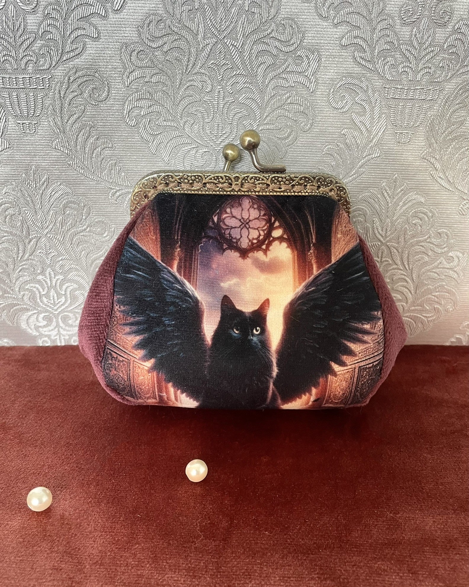 Porte-monnaie artisanal avec illustration d'un chat noir à ailes de corbeau dans une cathédrale gothique, style witchy.