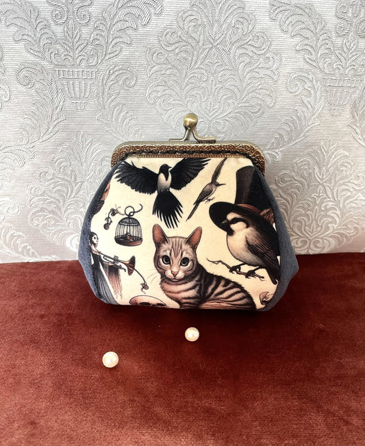 Porte-monnaie artisanal avec illustration d'un chat tigré entouré d'oiseaux fantastiques et côtés en velours bleu