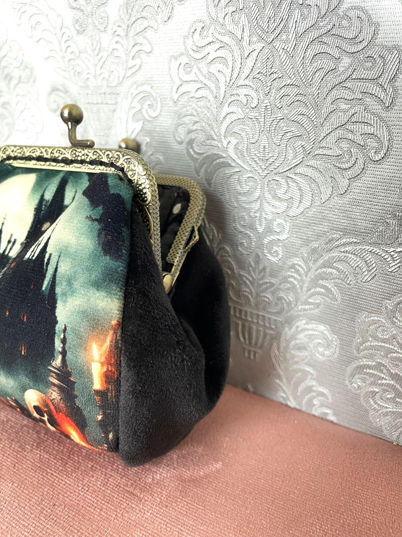 Vue de profil du porte-monnaie en velours noir avec son fermoir