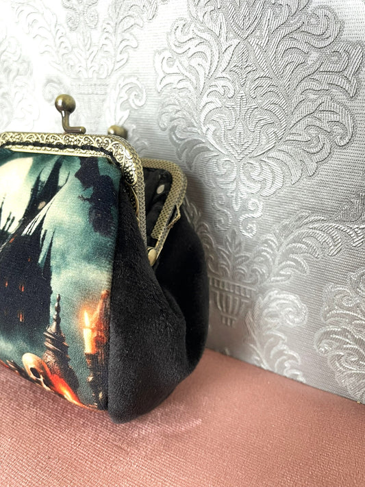 Vue de profil du porte-monnaie en velours noir avec son fermoir