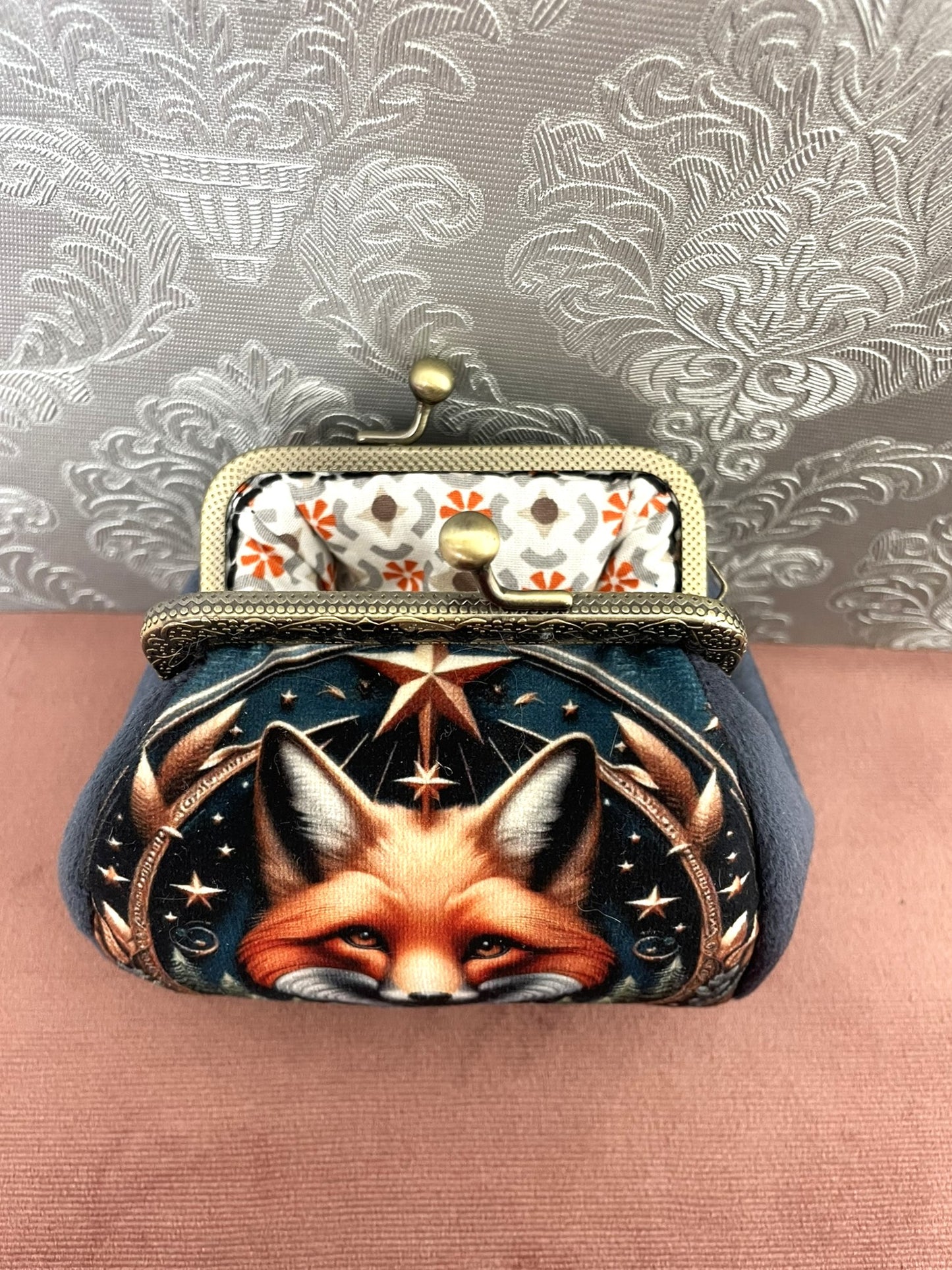 Intérieur ouvert d'un porte-monnaie artisanal dévoilant une doublure en coton aux motifs graphiques orange terracotta et gris.