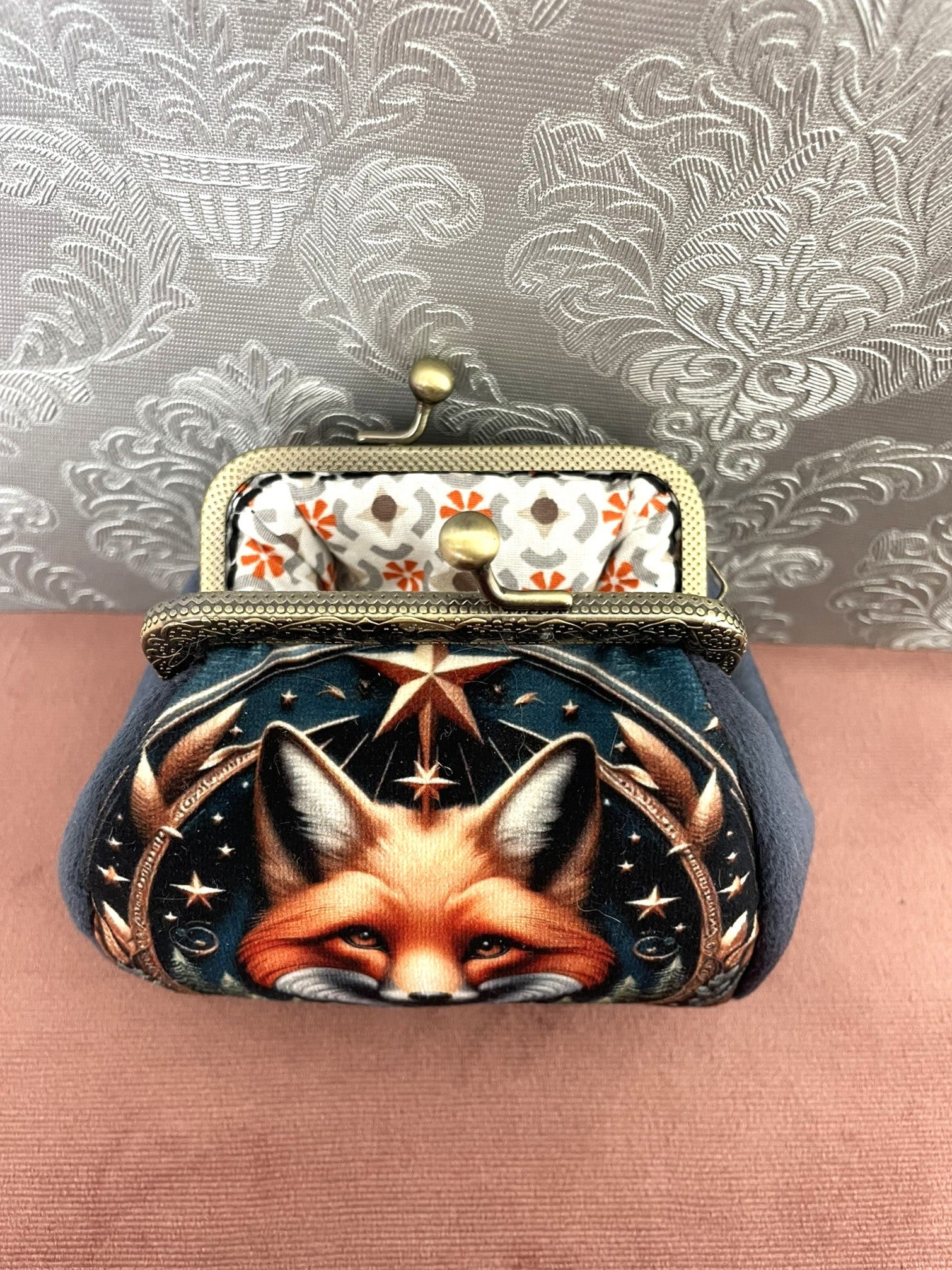 Intérieur ouvert d'un porte-monnaie artisanal dévoilant une doublure en coton aux motifs graphiques orange terracotta et gris.