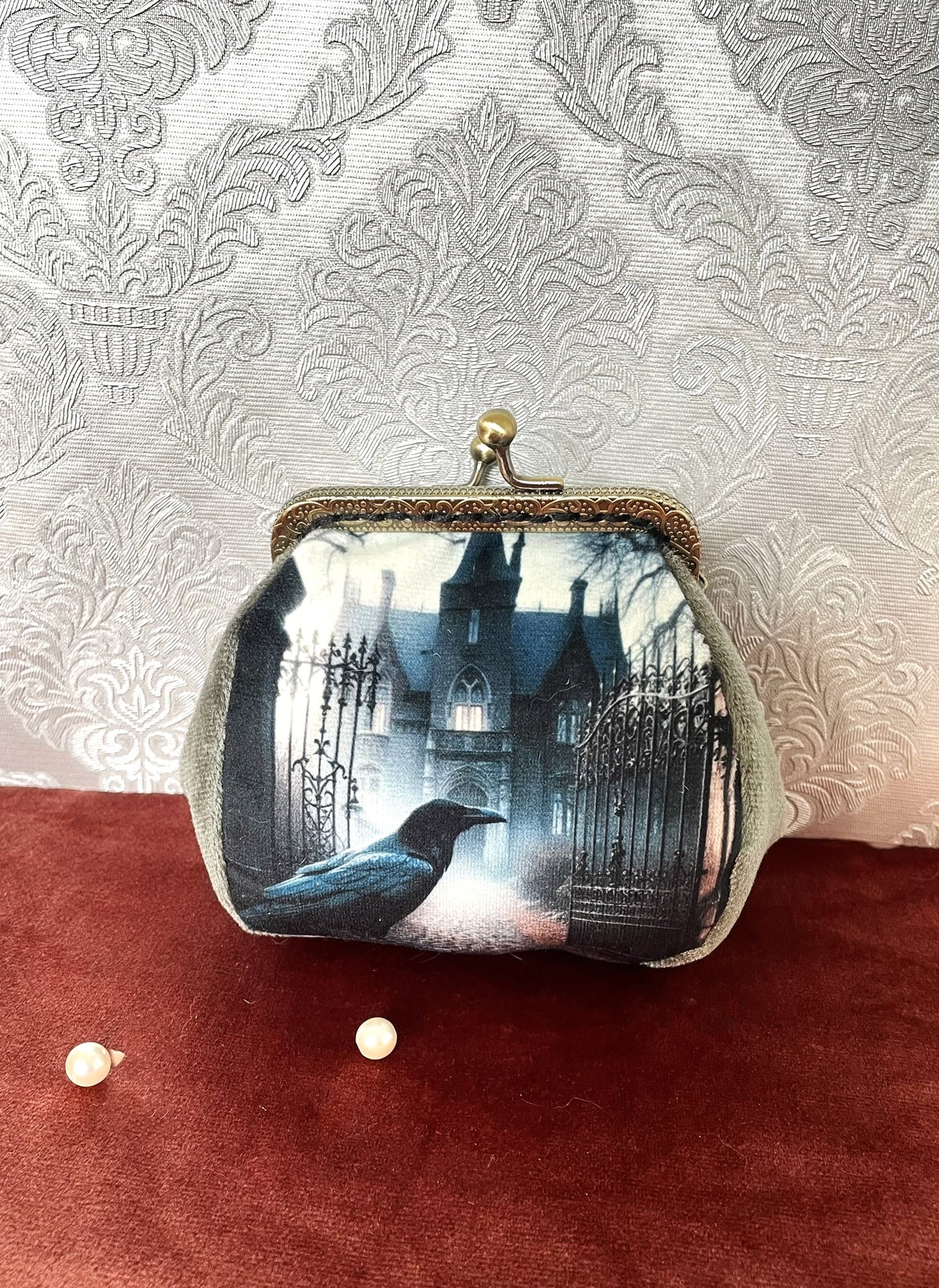 Porte-monnaie vintage avec illustration d'un corbeau noir devant un manoir gothique embrumé, style victorien.