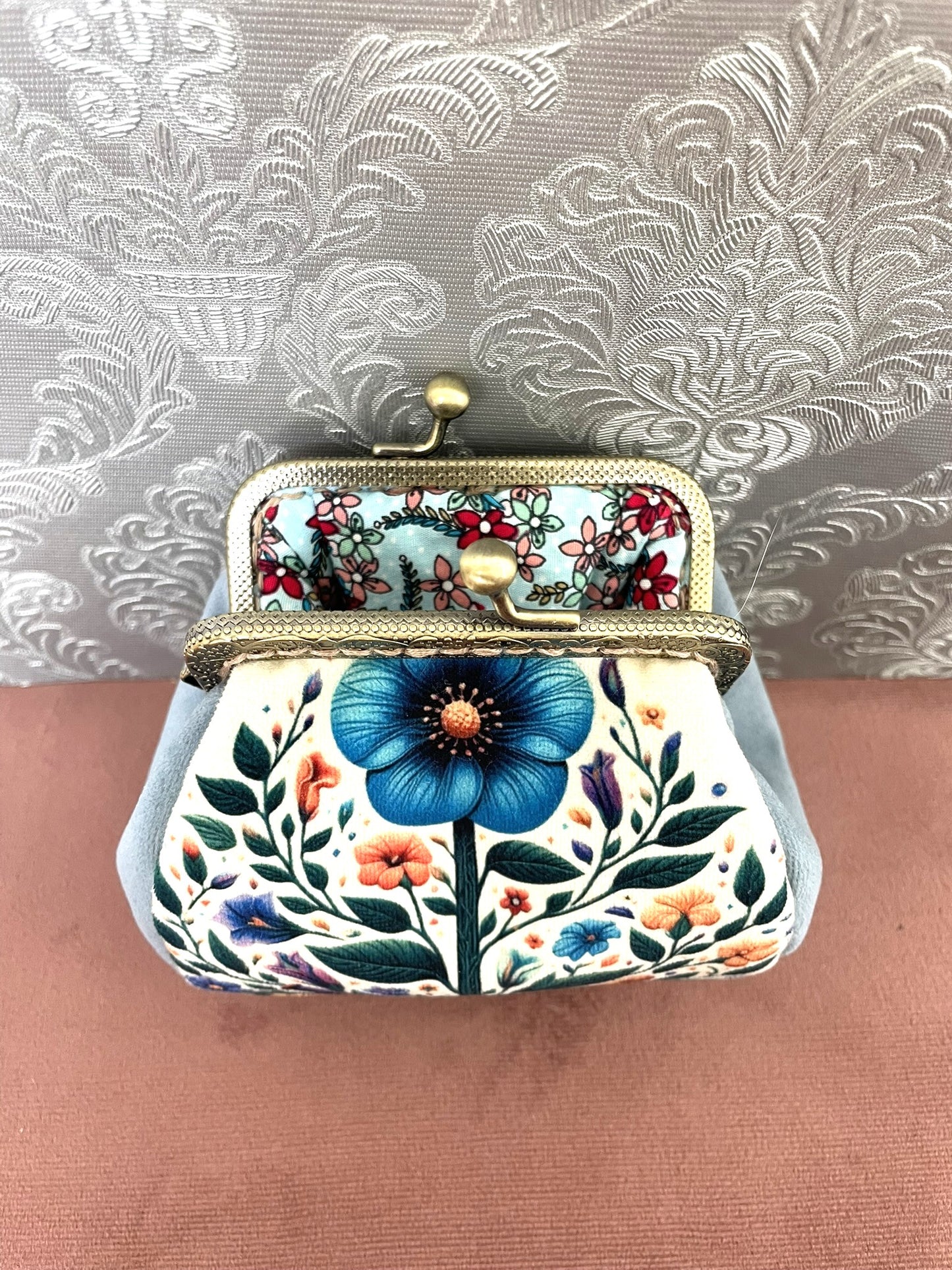 Intérieur ouvert d'un porte-monnaie rétro révélant une doublure en coton bleu aqua à motifs petites fleurs champêtres.
