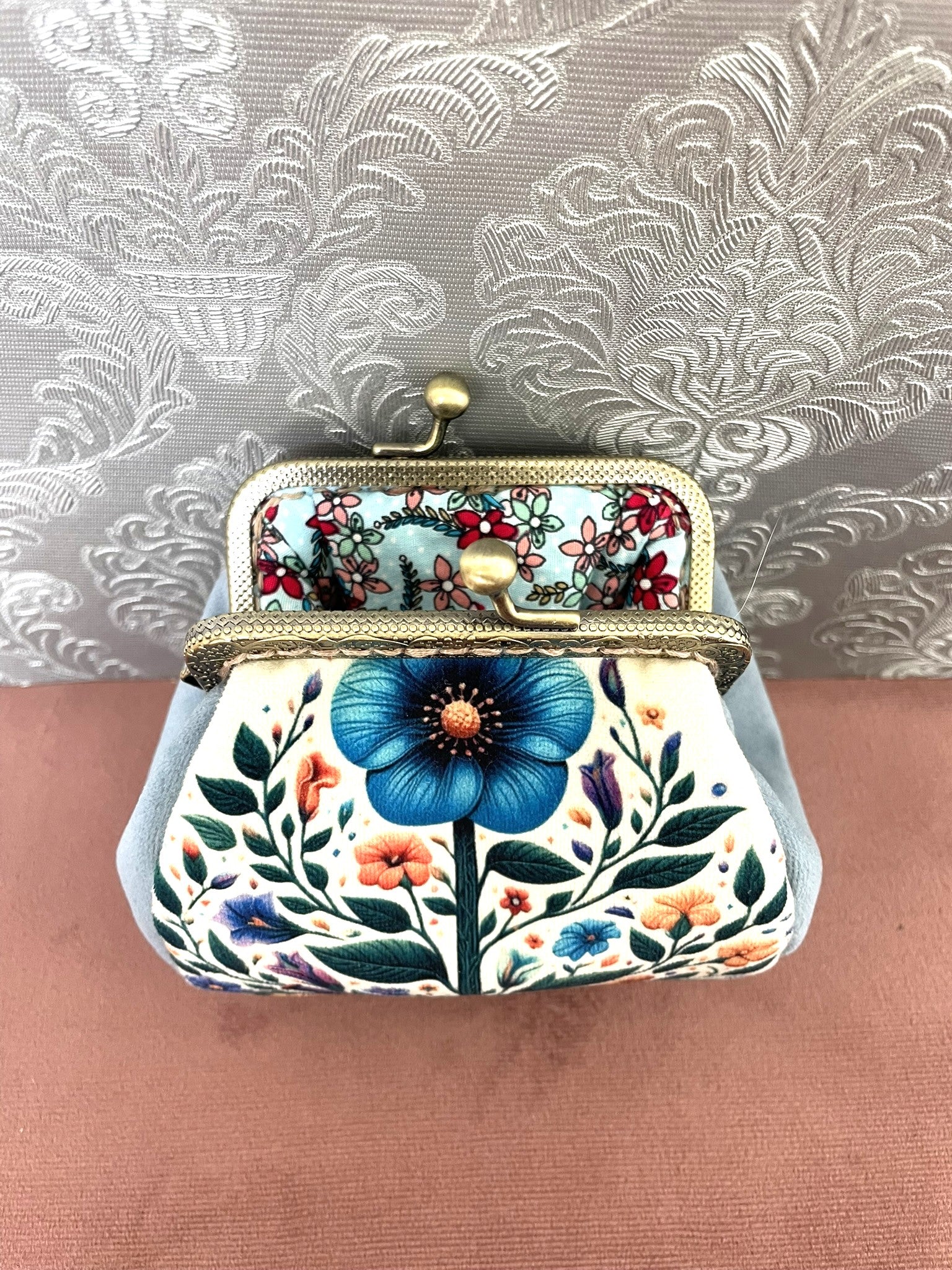 Intérieur ouvert d'un porte-monnaie rétro révélant une doublure en coton bleu aqua à motifs petites fleurs champêtres.