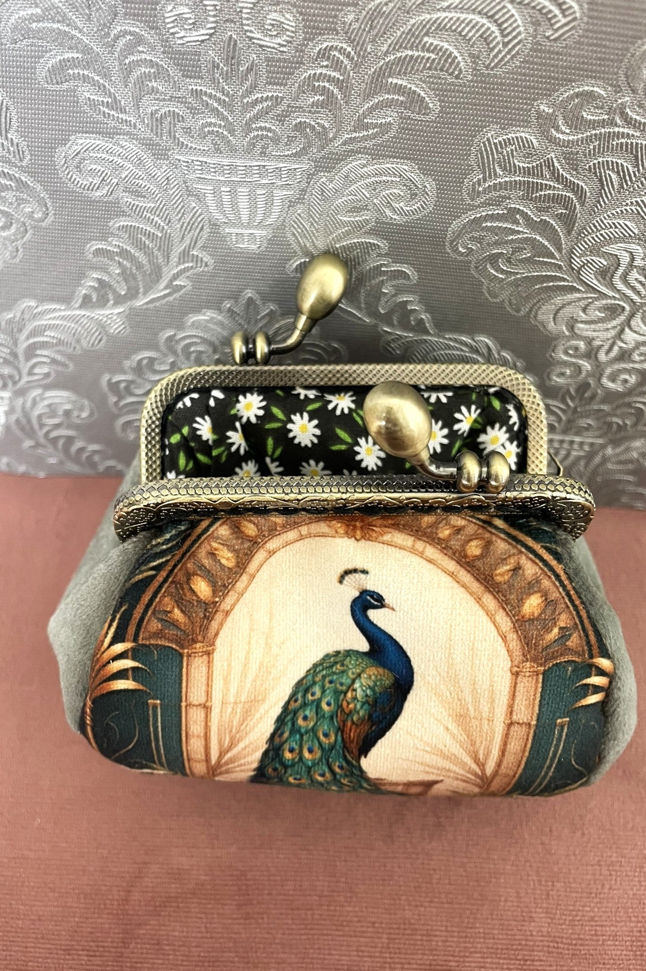 Intérieur ouvert d'un porte-monnaie rétro révélant une doublure en coton noir à motifs marguerites blanches.