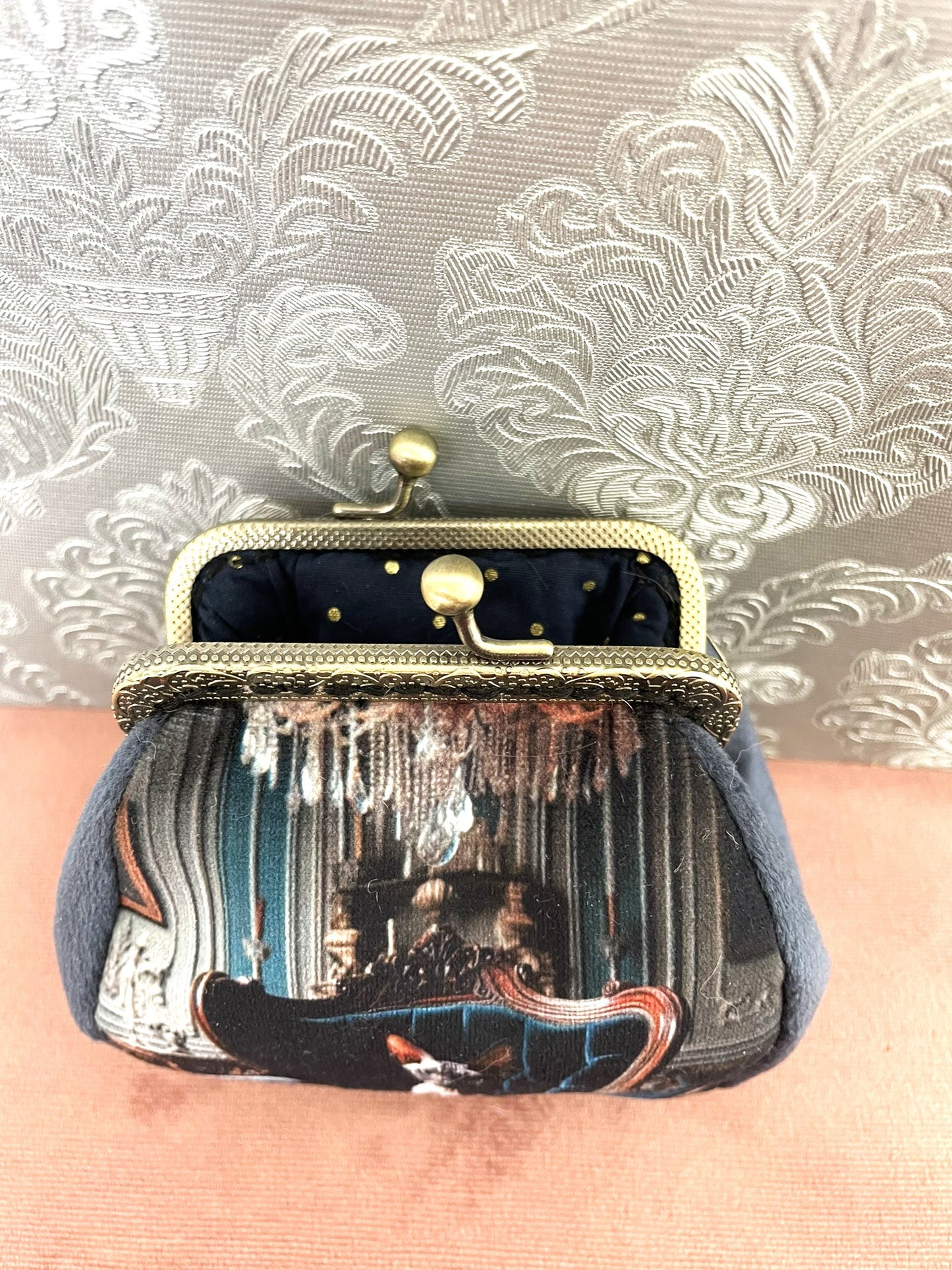 Intérieur ouvert d'un porte-monnaie rétro montrant une doublure en coton bleu marine à pois dorés scintillants.