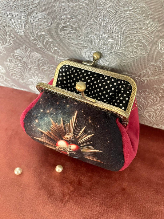 Vue intérieure du porte-monnaie montrant la doublure noire à pois blancs et le cadre métallique rétro.