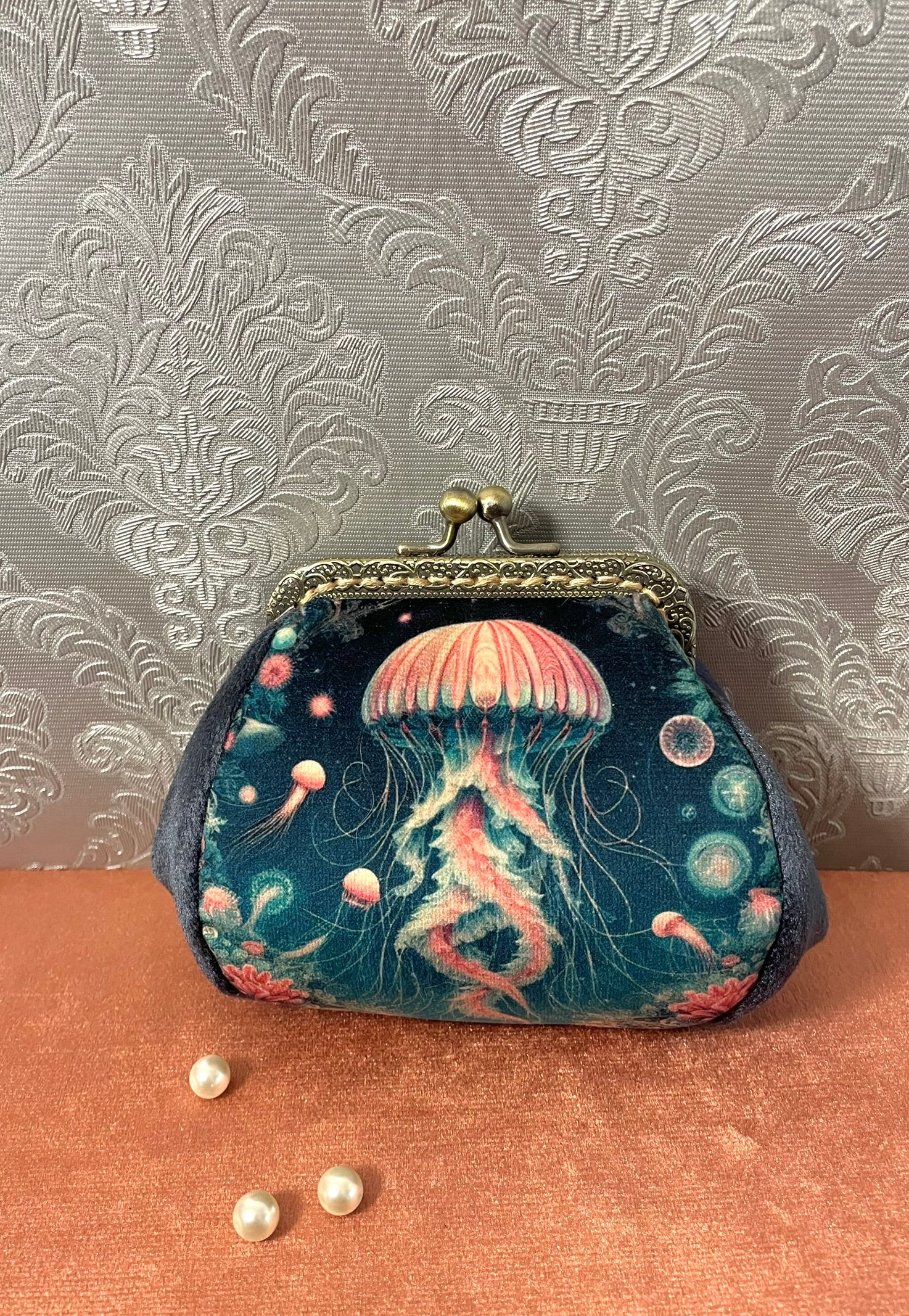 Porte-monnaie textile avec illustration de méduse rose sur fond bleu nuit et velours.
