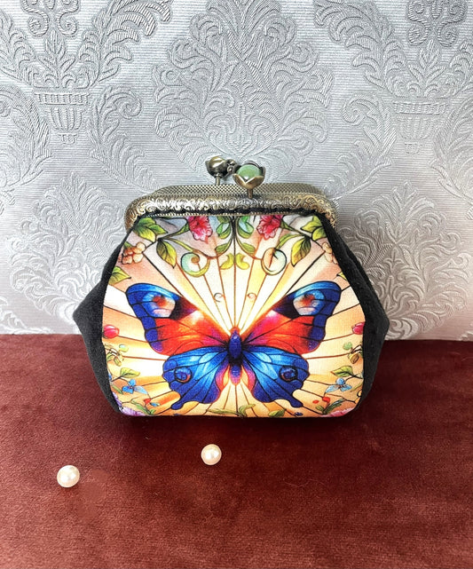 Porte-monnaie rétro avec illustration de papillon style vitrail rouge et bleu vif et côtés en velours noir, création artisanale.
