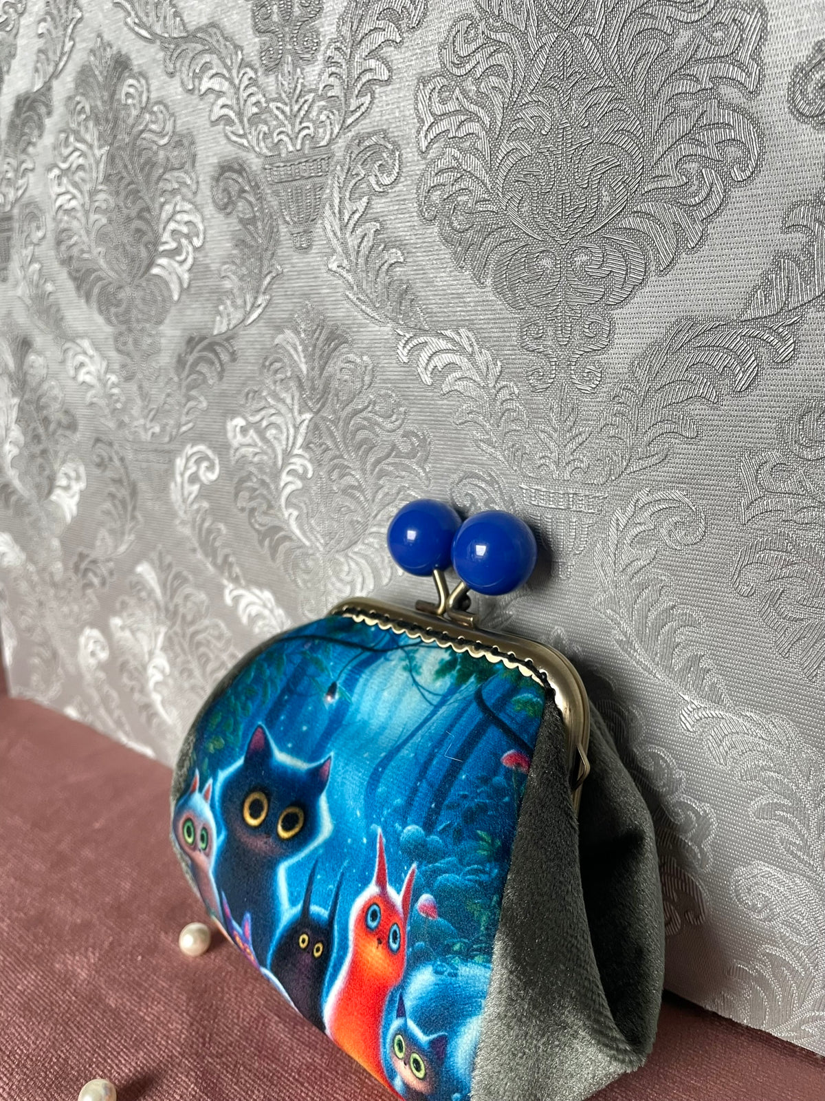 Vue de trois-quarts porte-monnaie rétro chats féériques et fermoir bronze à boules bleues Le Comptoir de Suzanne