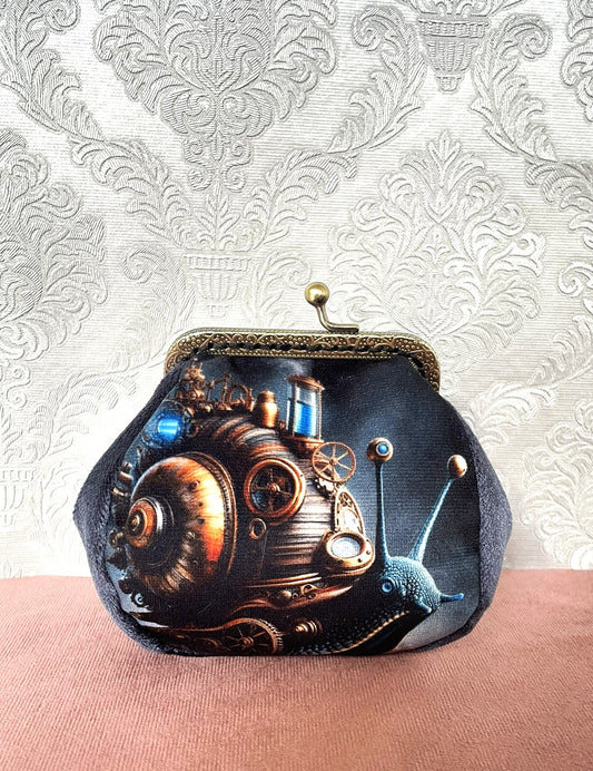 Porte-monnaie vintage steampunk avec illustration d'escargot mécanique sur velours sombre.