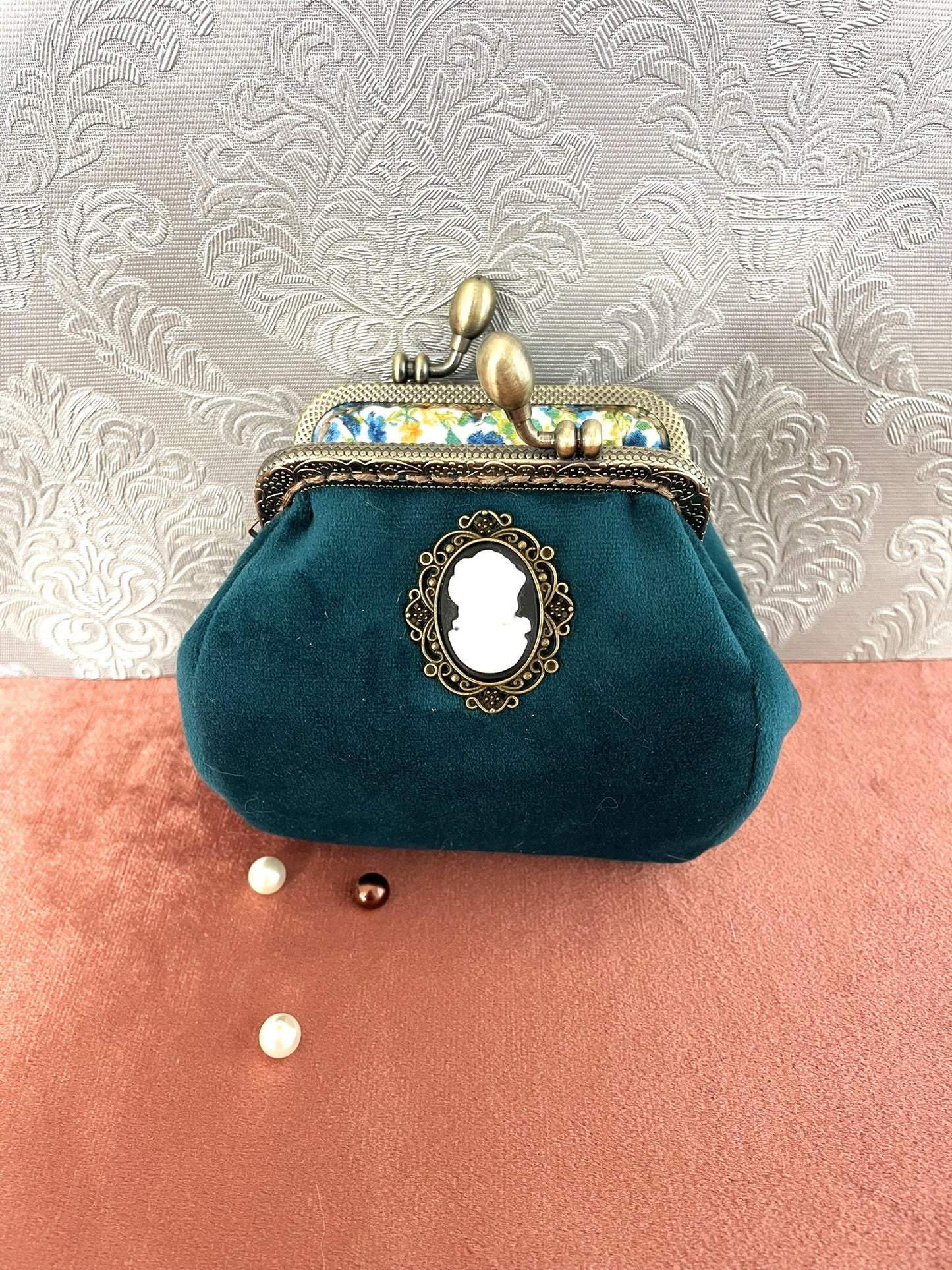 Vue de l'intérieur du porte-monnaie bleu canard ouvert révélant une doublure en coton fleurie jaune et bleue.