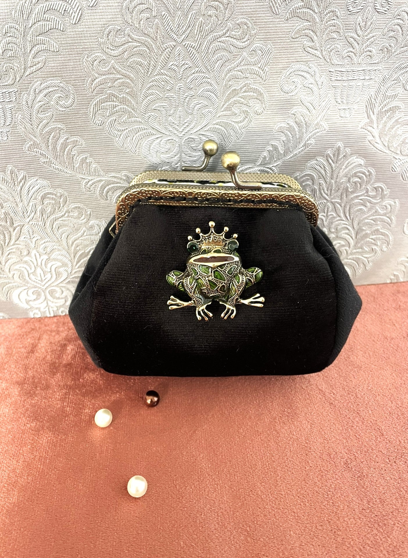 Porte-monnaie artisanal en velours noir orné d'une broche grenouille couronnée en émail vert et d'un fermoir rétro en bronze.