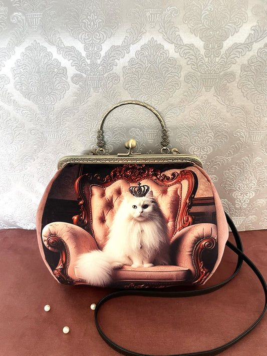 Zoom sur le fermoir rétro en métal bronze ciselé et la doublure fleurie style Liberty d'un sac à main artisanal orné d'un chat blanc à couronne - Le Comptoir de Suzanne