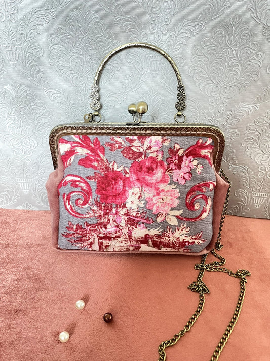 Sac à main rétro avec motif Toile de Jouy gris et roses fushia éclatantes, sur un fond vieux rose en velours.