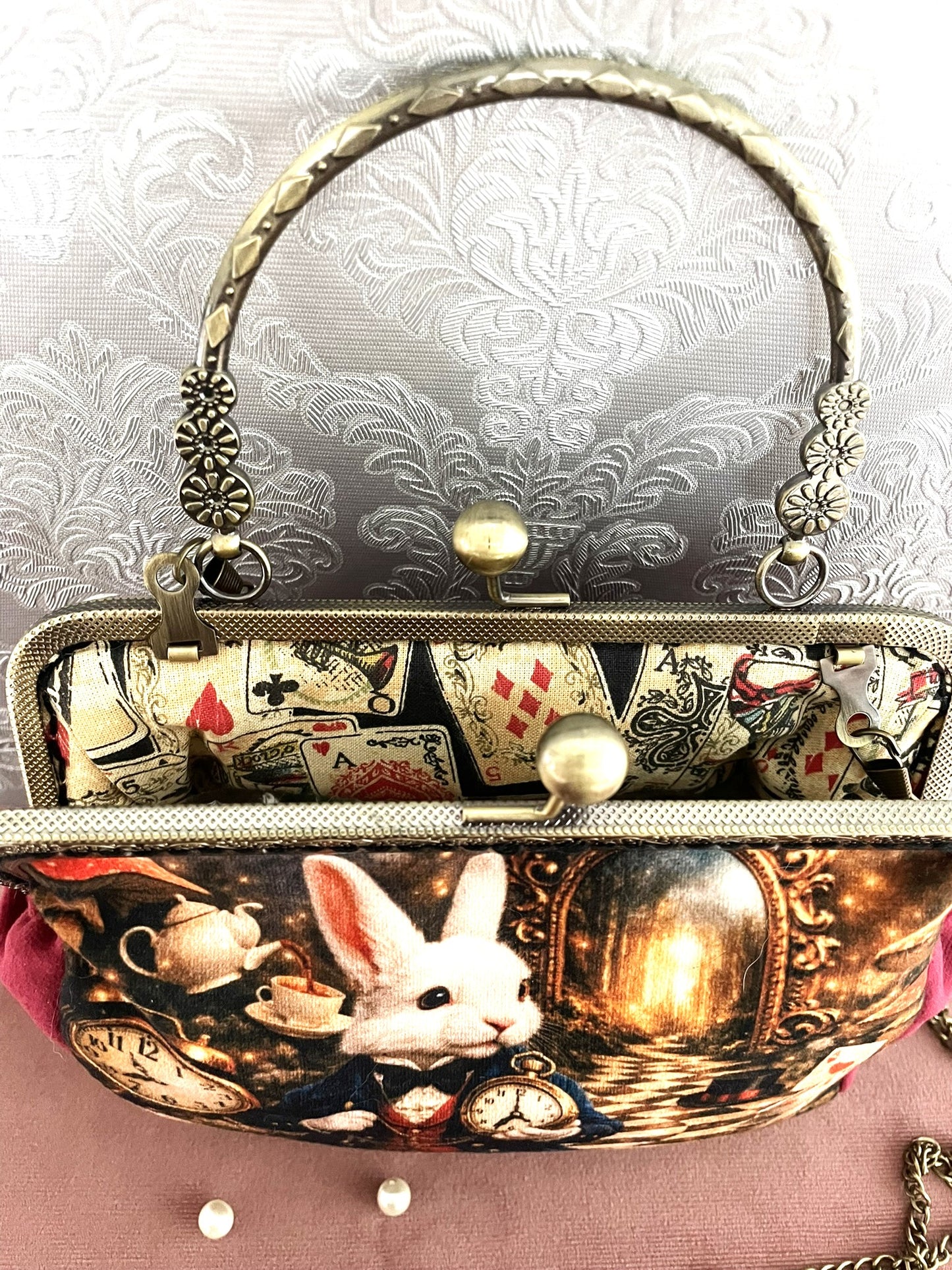 Sac à main clic-clac vintage ouvert montrant une magnifique doublure intérieure en coton illustrée de cartes à jouer rétro (as de pique, roi de cœur).
