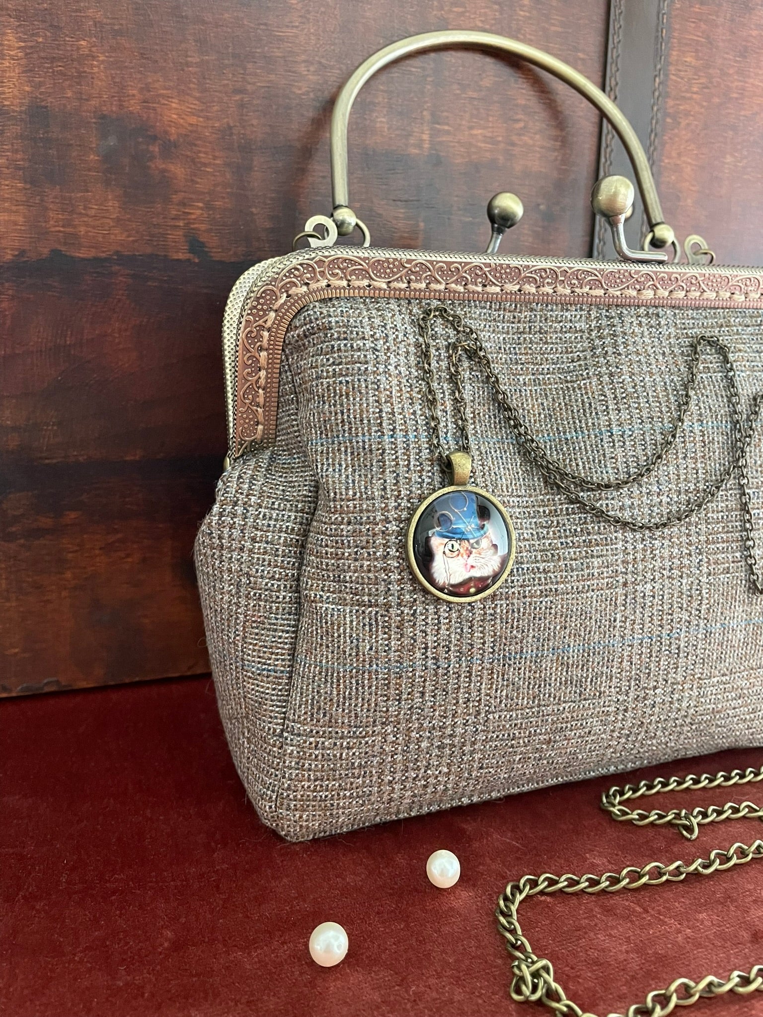 Vue de profil du sac artisanal en tweed avec détails de l'armature métallique ciselée.