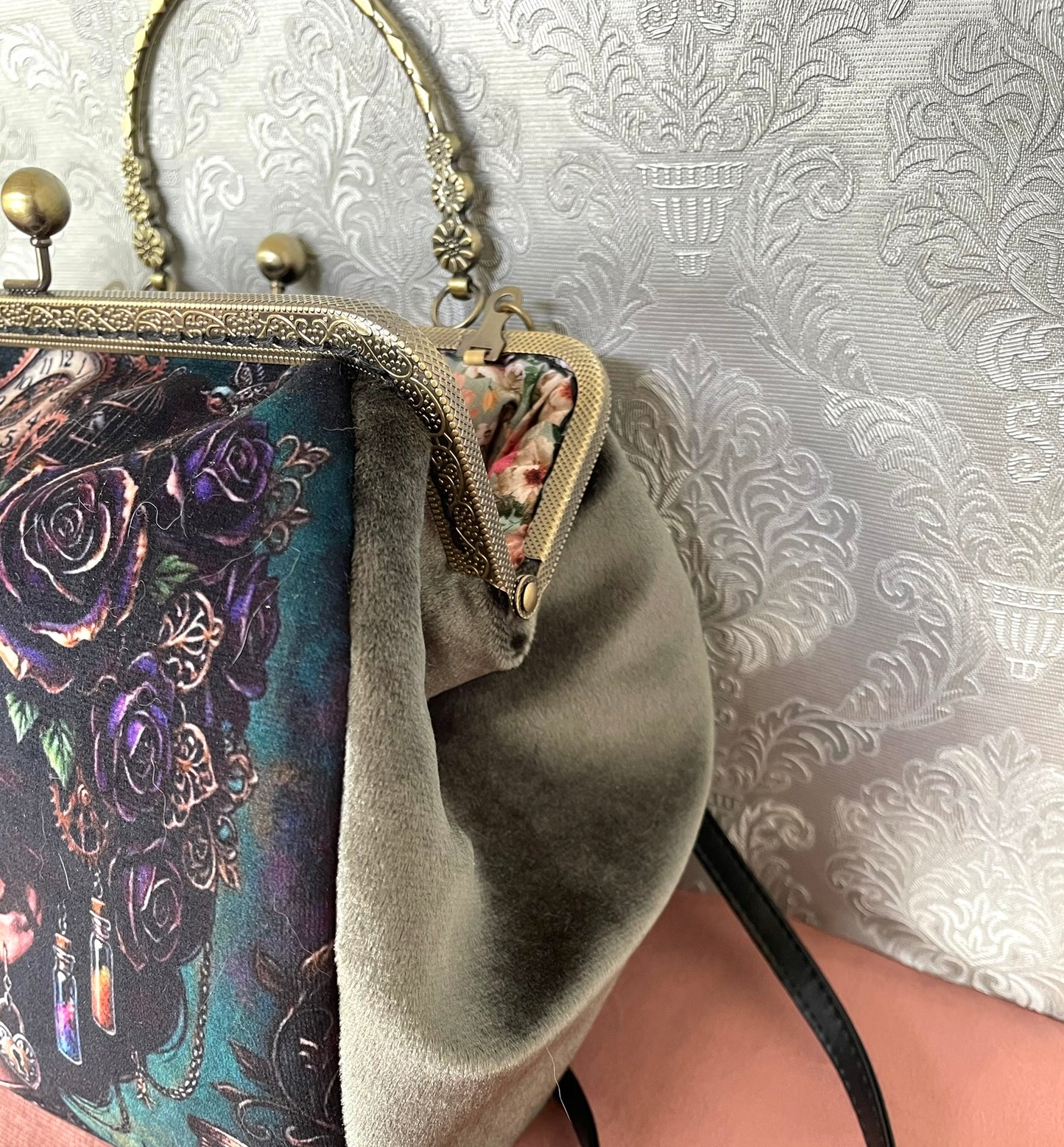 Côté en velours vert olive et détails du fermoir métallique à poignée effet bronze sur un sac de créateur.