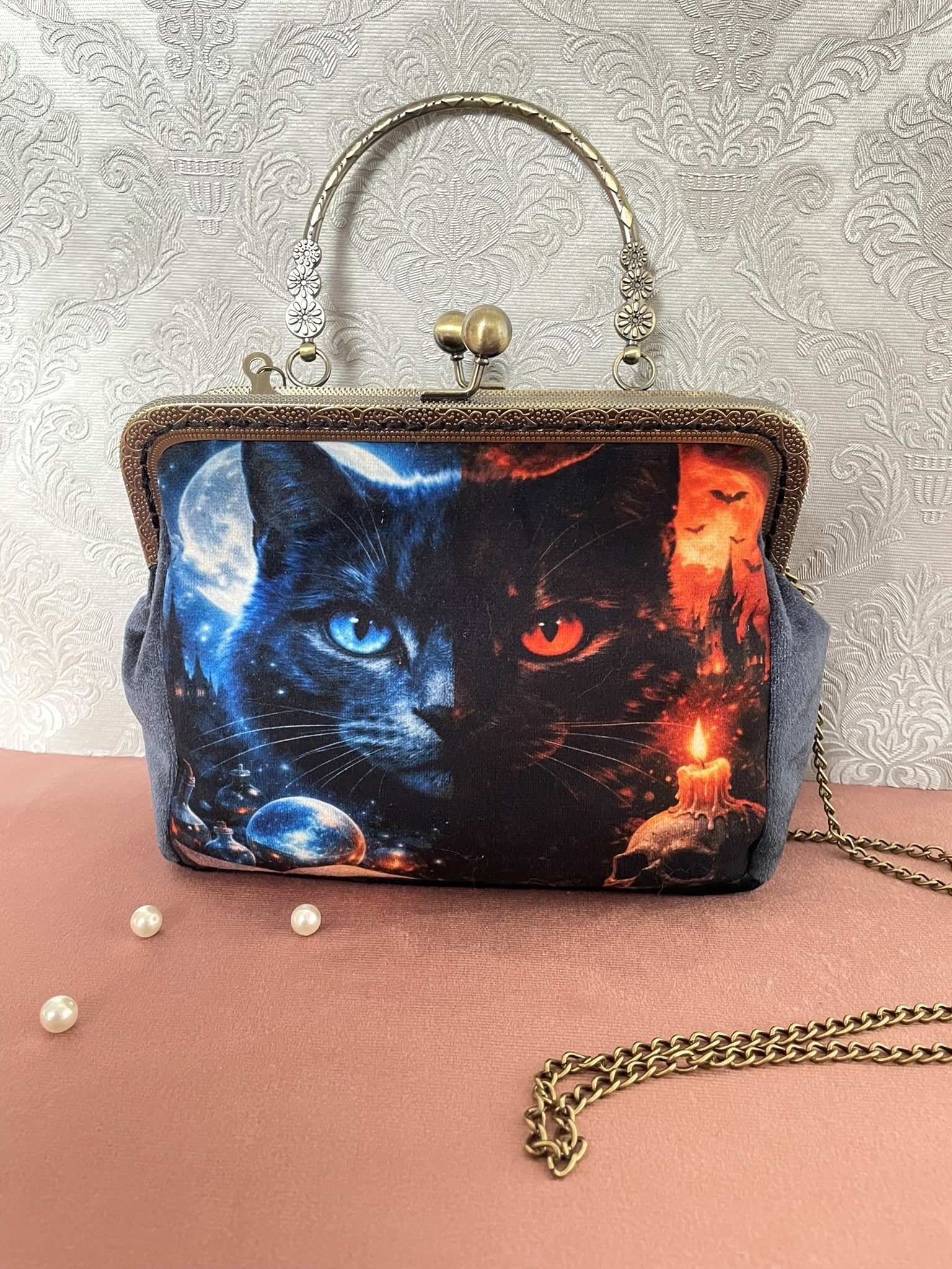 Sac pochette gothique en velours avec illustration de chat mystique noir aux yeux vairons bleu et rouge, chaîne dorée et fermoir rétro clac.