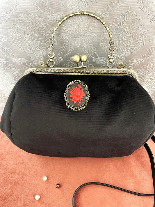 Sac à main gothique romantique en velours noir avec un grand camée orné d'une rose rouge.