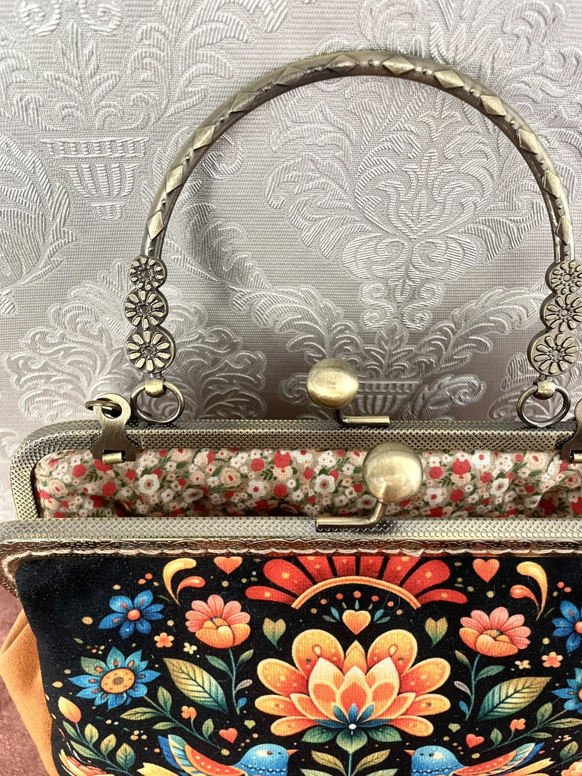 Vue interieur doublure fleurie et fermoir effet bronze d'une pochette retro folk Le Comptoir de Suzanne