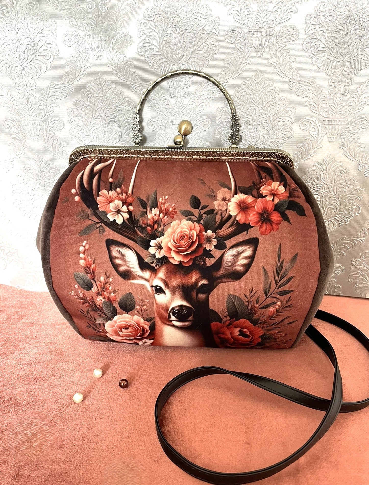 Détail de la poignée rigide en métal bronze ciselé de motifs floraux.