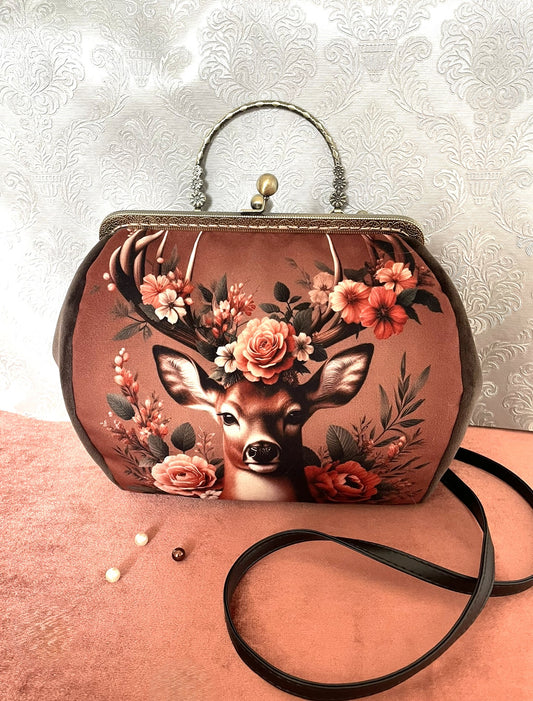 Détail de la poignée rigide en métal bronze ciselé de motifs floraux.