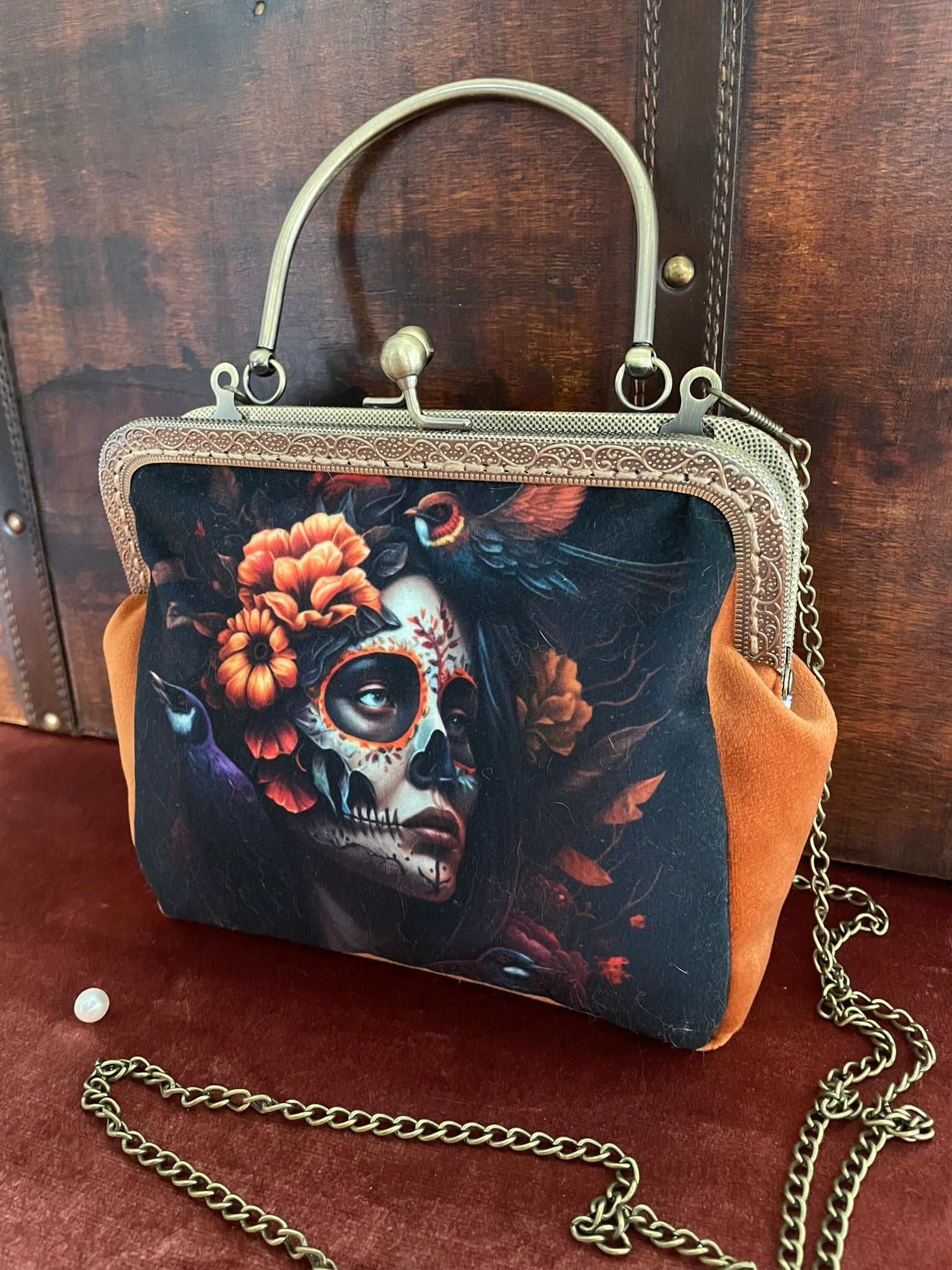 Sac de créateur porté main avec poignée rigide, style chic et mystique.