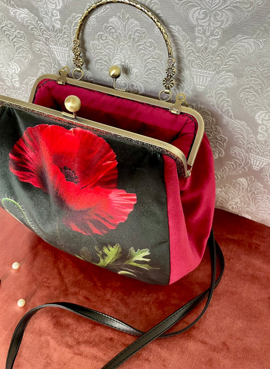 Vue du fermoir bronze antique ouvert révélant la doublure intérieure rouge vif du sac coquelicot.