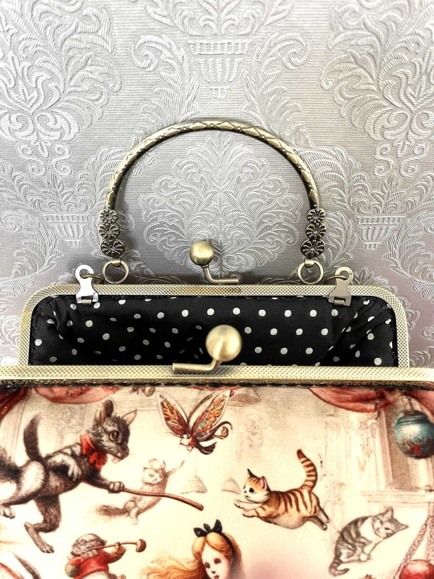 Intérieur ouvert du sac avec doublure graphique en coton noir à pois blancs.