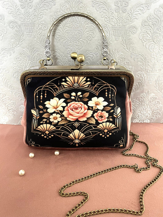 Gros plan latéral d'un sac rétro en velours rose poudré avec motif floral style Art Déco et fermoir baiser vintage en bronze.
