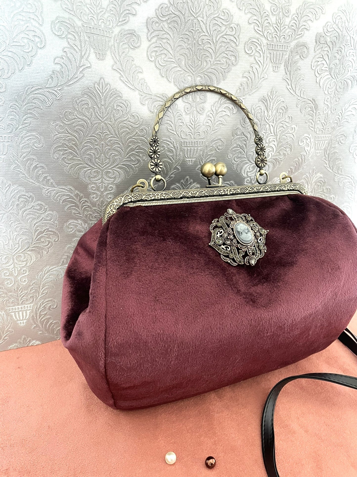 Sac victorien de profil montrant la bandoulière amovible et la poignée ciselée