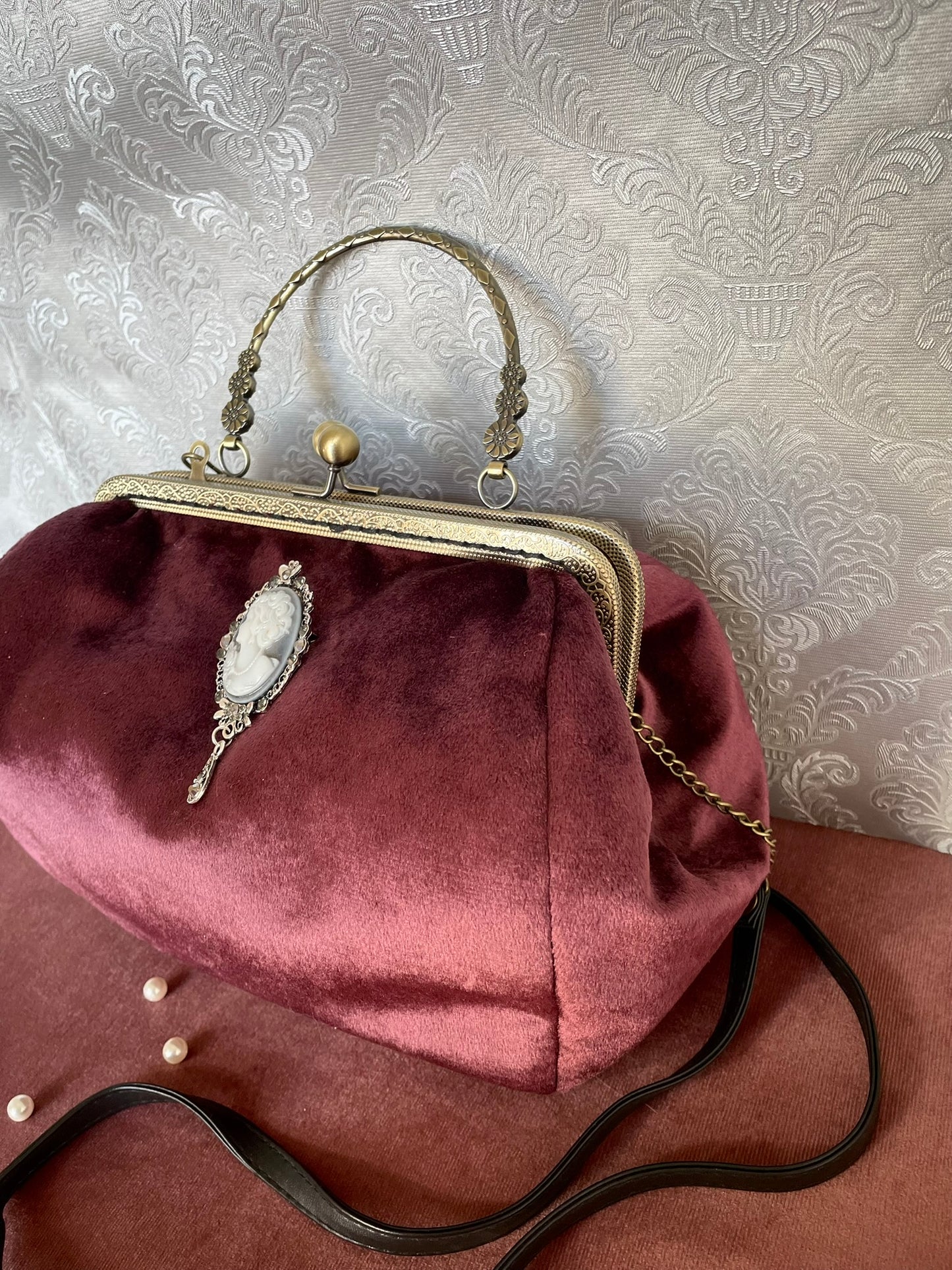 Sac à main rétro chic avec camée bijou sur velours bordeaux et bandoulière noire - Le Comptoir de Suzanne.