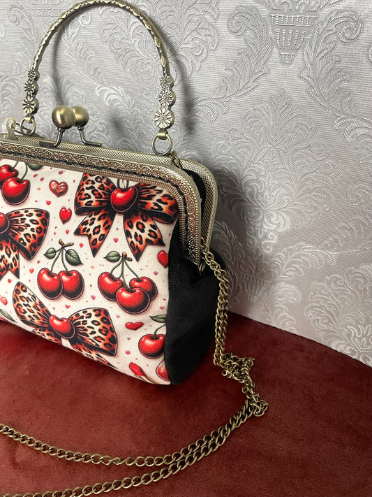 Vue de profil sac retro velours noir motif cerises et noeuds leopard avec chainette bronze Le Comptoir de Suzanne