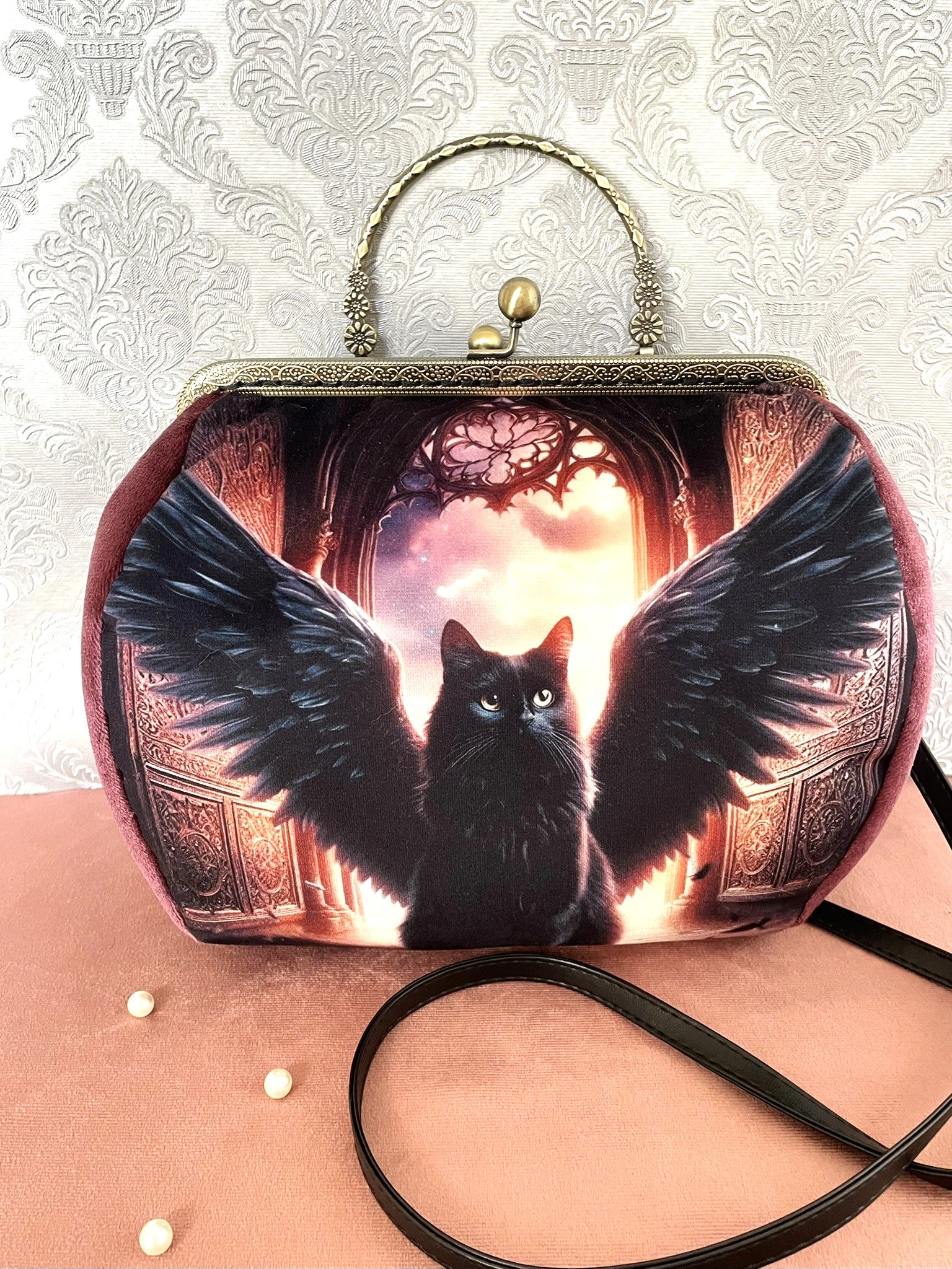 sac à main rétro fait main représentant un chat noir avec des ailes d'ange devant une rosace gothique.