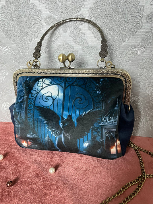 Gros plan sur le fermoir baiser et la poignée rigide en bronze antique finement gravés