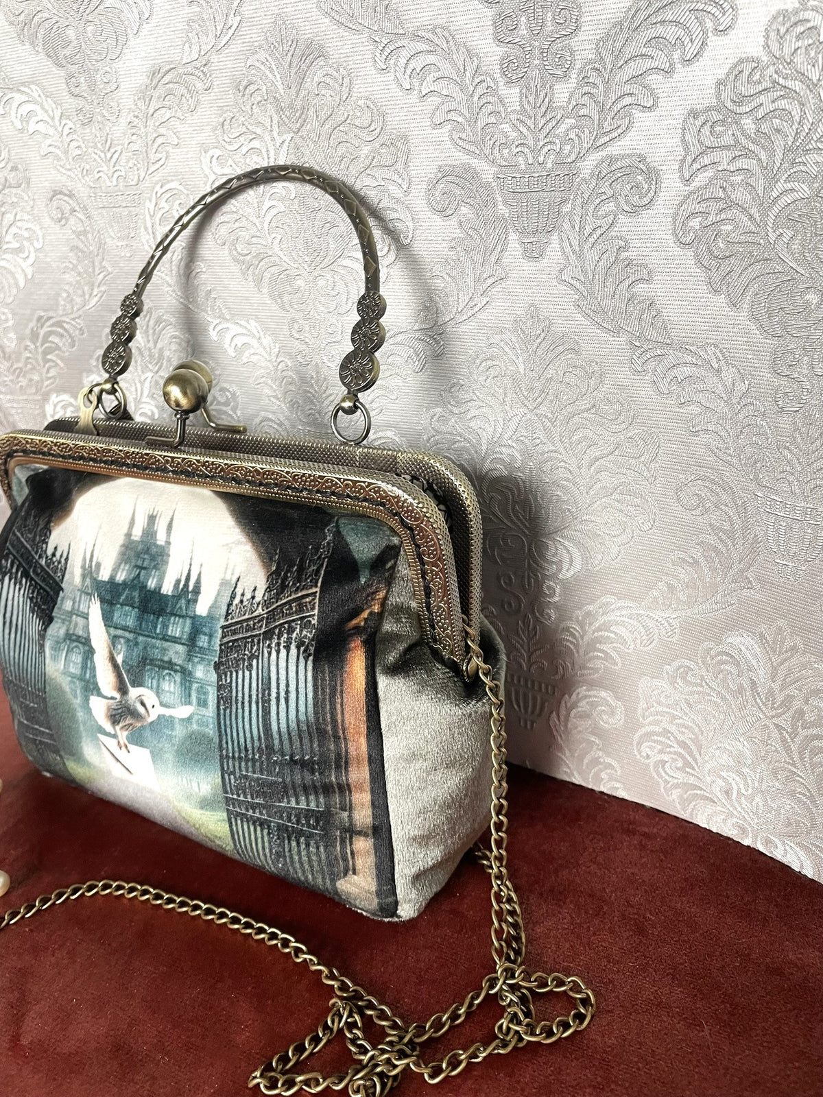 Vue de trois-quarts sac retro velours vert de gris motif chouette magique et chateau avec chainette bronze Le Comptoir de Suzanne