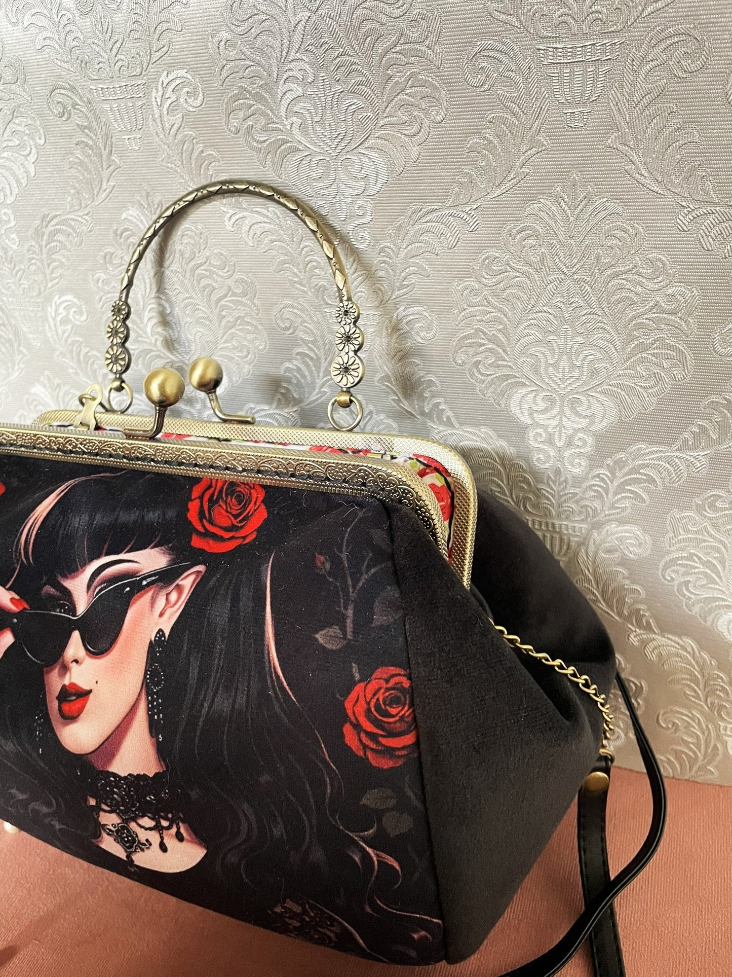 Vue de profil du sac à main rétro en velours noir avec bandoulière et fermoir bronze ciselé.