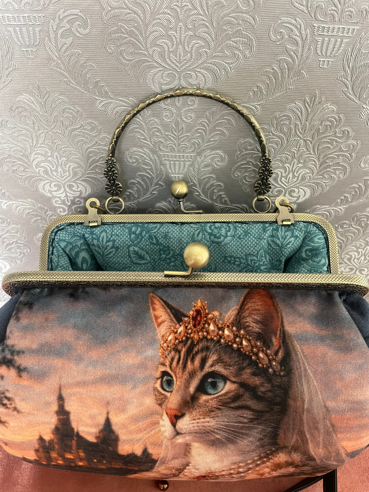 Gros plan fermoir bronze et doublure turquoise arabesques sac rétro chat reine