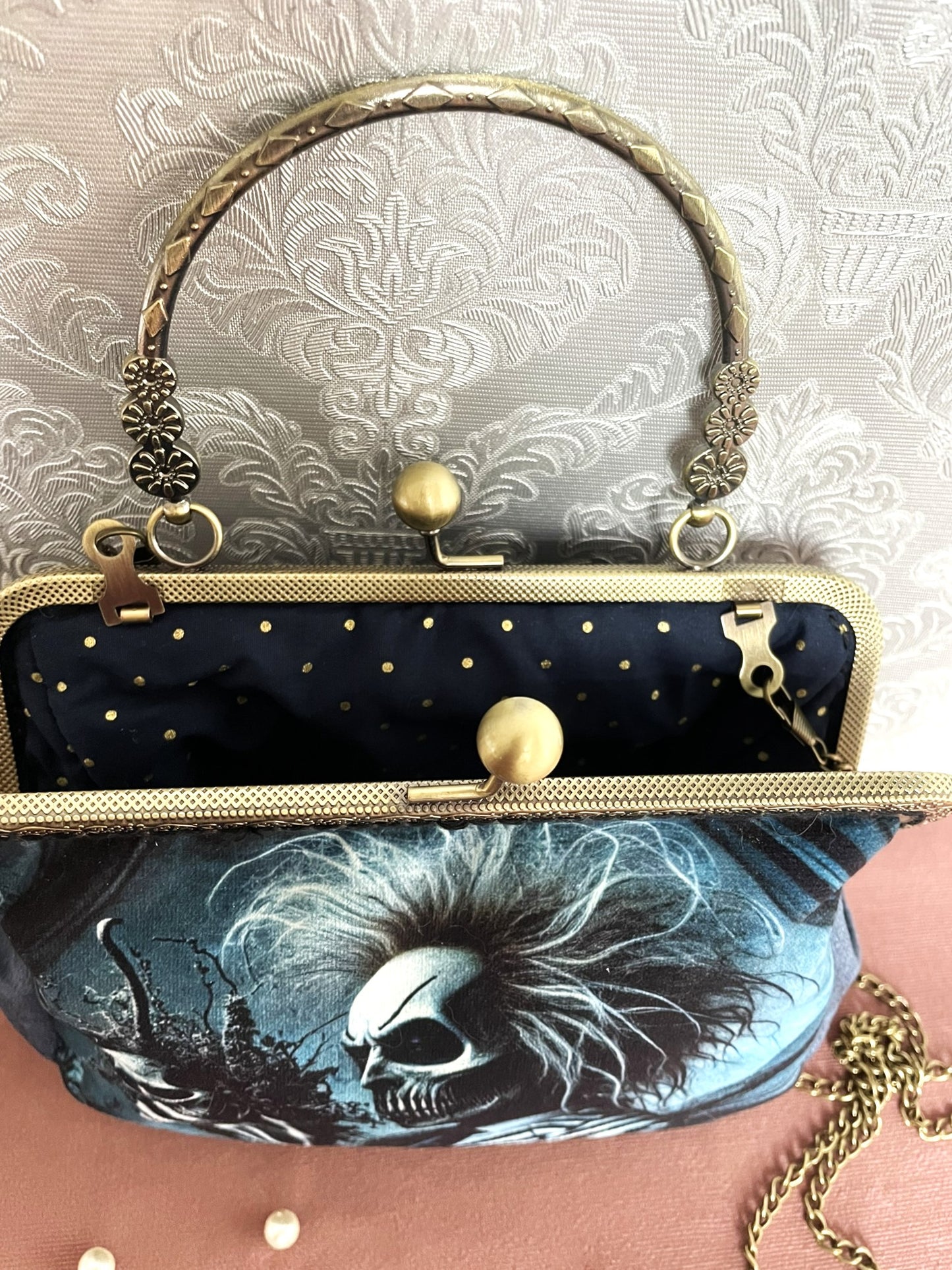 Sac à main gothique rétro ouvert montrant une doublure intérieure bleu marine parsemée de petits pois dorés étincelants.