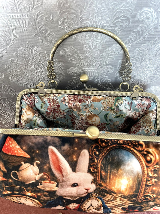 Vue interieur doublure bleu ciel fleurie et fermoir bronze d'un sac retro alice au pays des merveilles