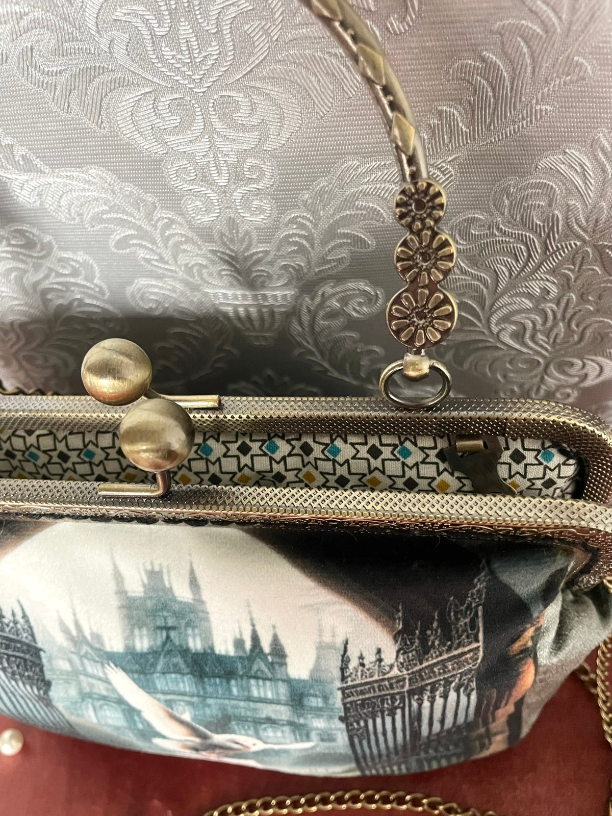 Gros plan fermoir effet bronze ciselé et doublure coton géométrique d'un sac retro chouette