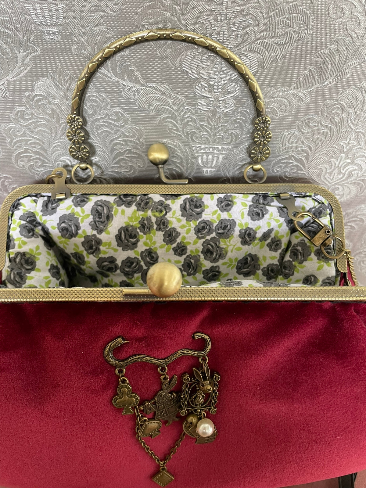 Vue rapprochée du fermoir couleur bronze ouvert et de la doublure coton à roses grises sac rouge Le Comptoir de Suzanne