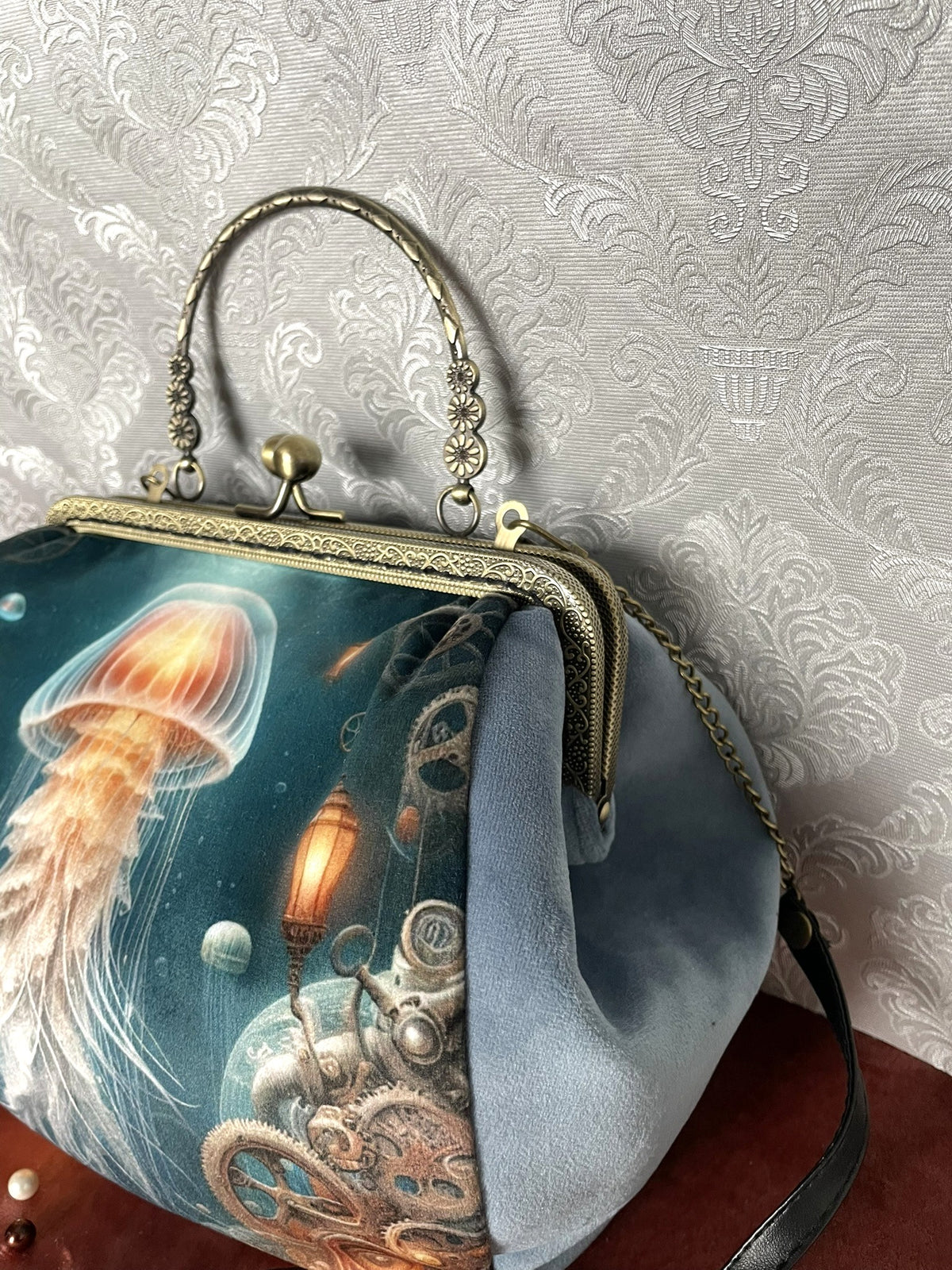 Vue de trois-quarts sac retro velours bleu motif meduse lumineuse steampunk et engrenages avec fermoir