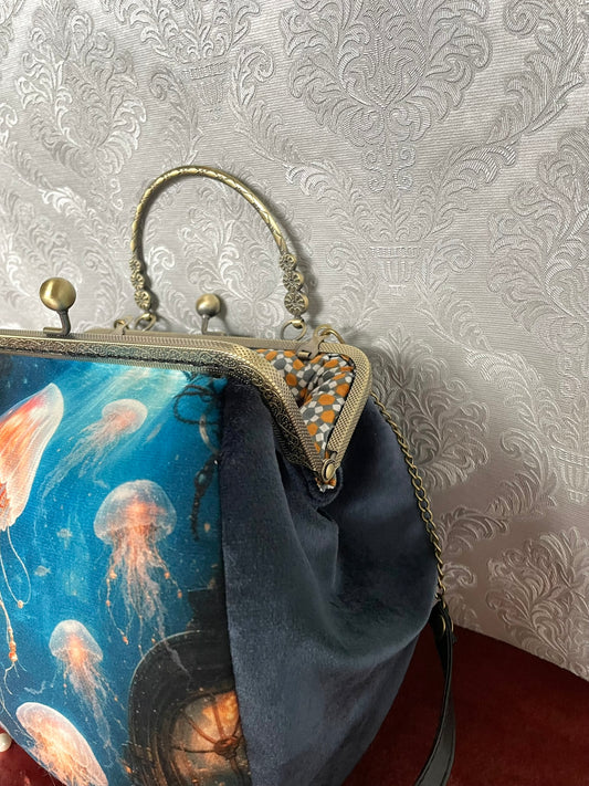 Gros plan fermoir effet bronze ciselé et doublure coton géométrique orange d'un sac retro méduses