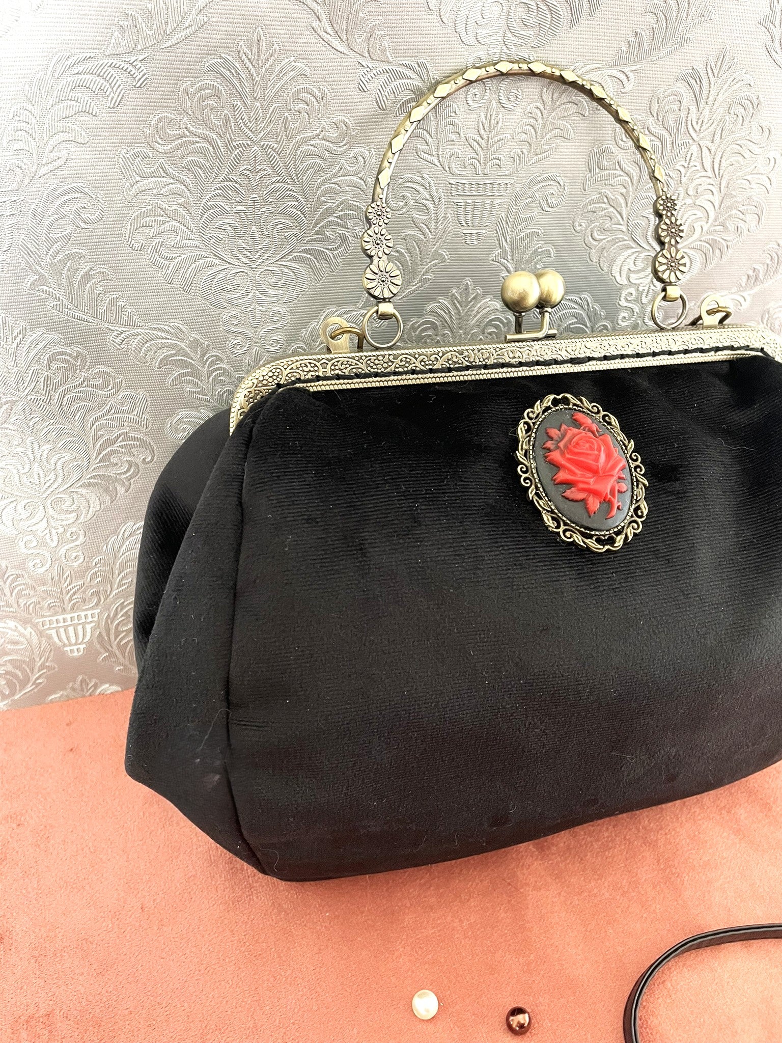 Vue de trois-quarts du sac rétro en velours noir montrant le volume et le fermoir kiss-lock bronze.