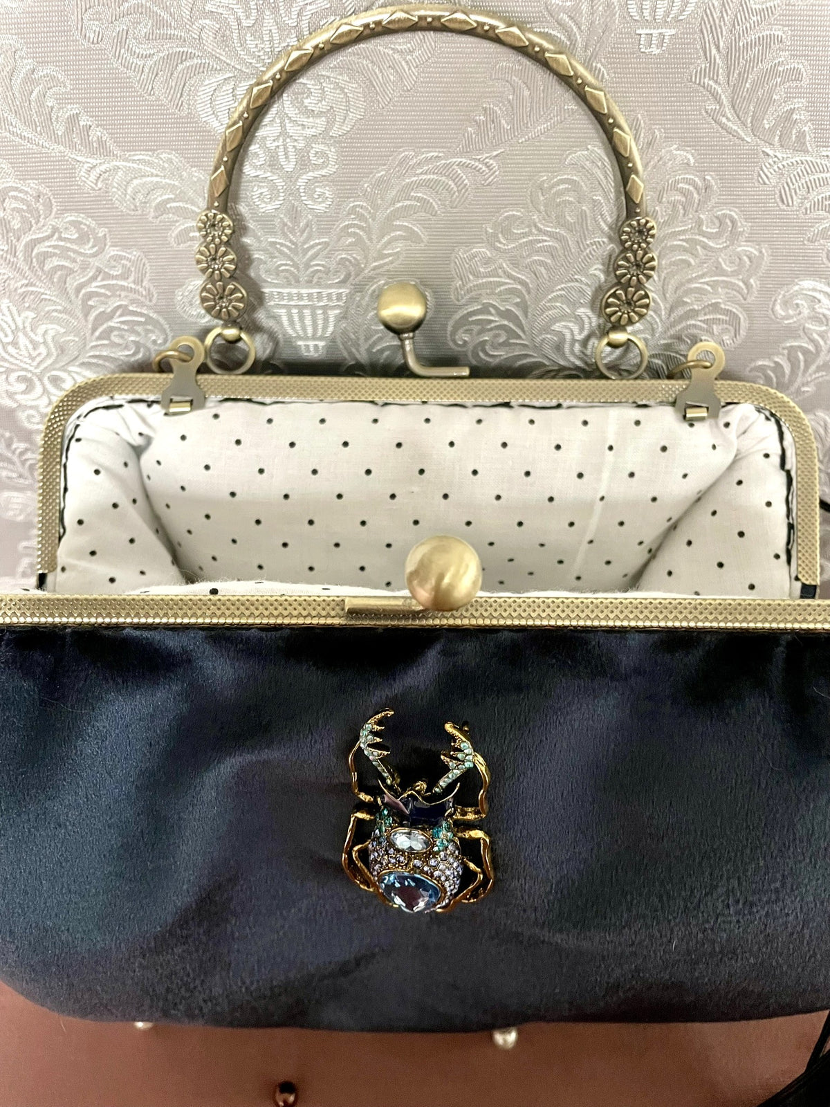 Vue du fermoir ouvert couleur bronze et de la doublure coton blanc à pois noirs sac bleu nuit Le Comptoir de Suzanne