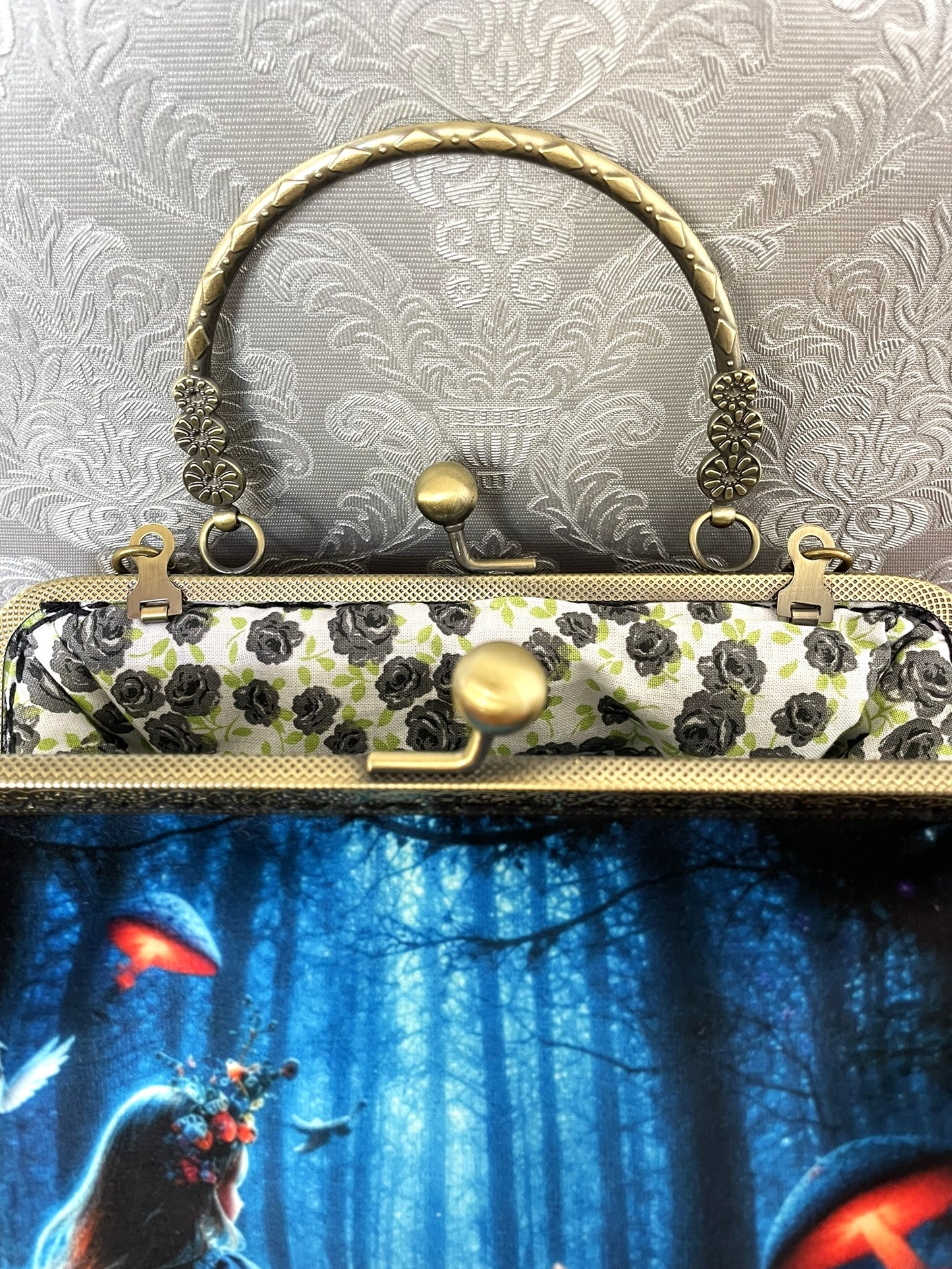 Gros plan sur le fermoir vintage effet bronze ciselé et la doublure en coton rose noire du sac rétro Alice