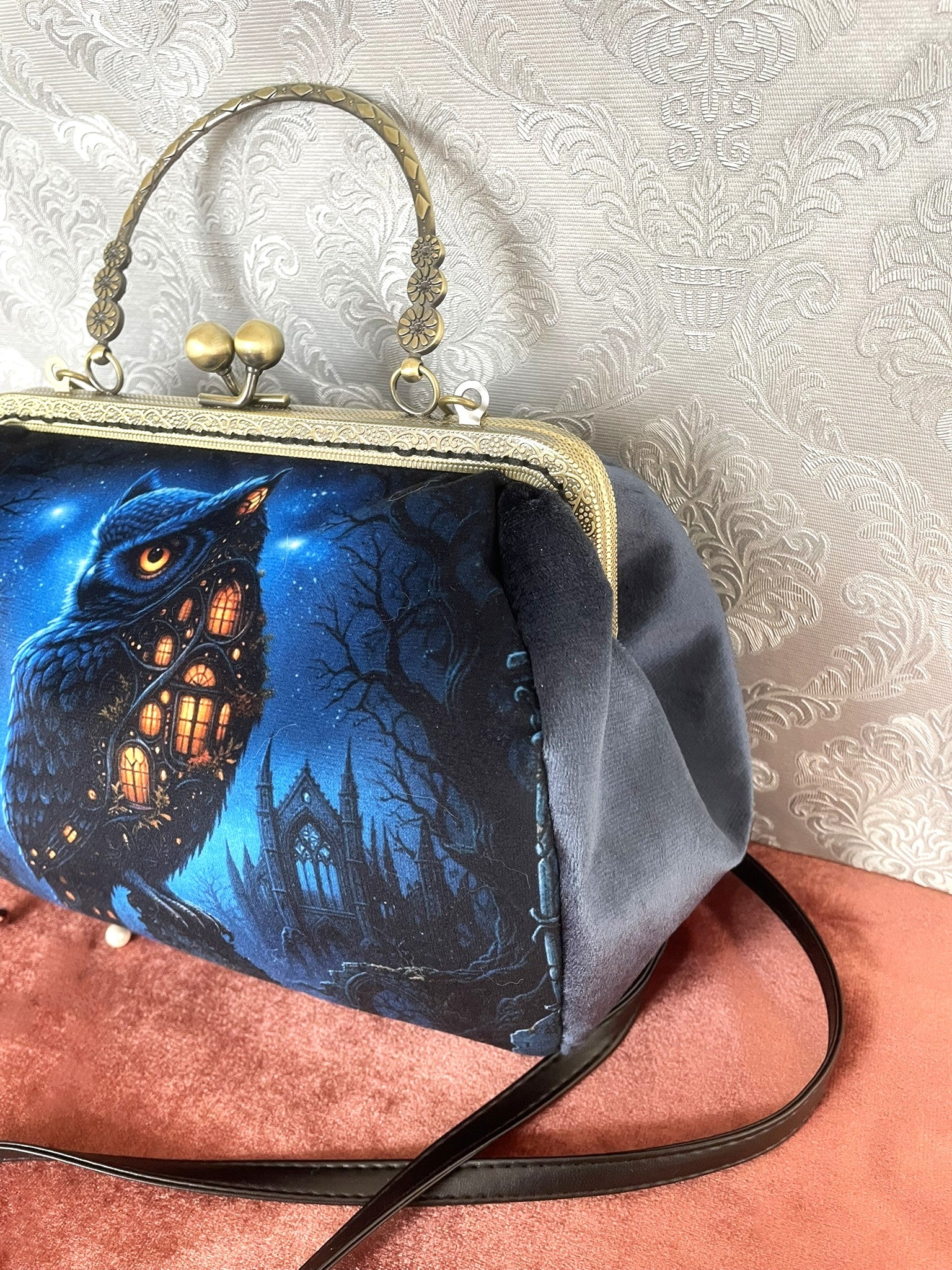 Sac rétro hibou nocturne vu de trois-quarts montrant le velours gris bleu, l'armature effet bronze et la bandoulière noire